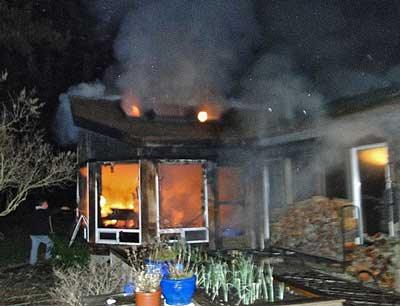 Smoke pours from the ceiling as fire engulfs the sunroom of a home on San Juan Island's Skottowe Lane late Saturday