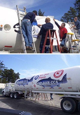 San Juan Propane employees place a 15-foot salmon decal on the company's newest truck