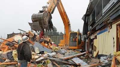 An MEM Enterprises crew begins the tear down and removal of the fire-ravaged Spring Street Landing Building