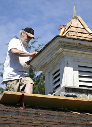 Dana Owens reroofs the cupola on the original county jail
