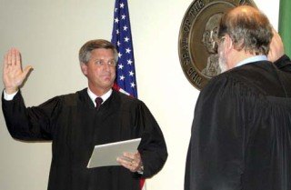 Superior Court Judge John Linde takes the oath of office from District Court Judge Stewart Andrew