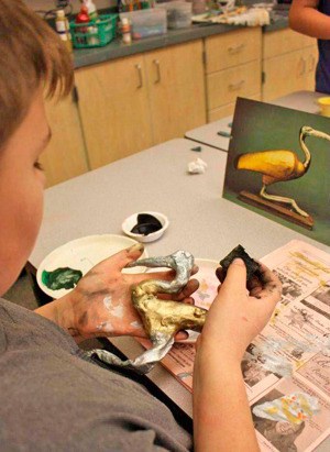 A middle school student at work on an art project.