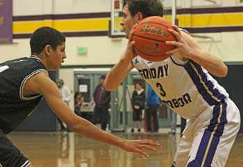 Friday Harbor's Dylan DeMaris scans the court for an open teammate in the Wolverines win at home