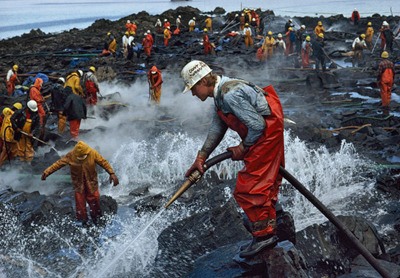 Workers don hardhats and wield firehoses as part of the massive cleanup that followed in the wake of the Exxon Valdez oil spill.