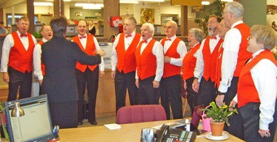 Director Angel Michaels and the Islands Chordsmen Plus deliver a singing Valentine's Day surprise at the Friday Harbor branch of Islanders Bank.