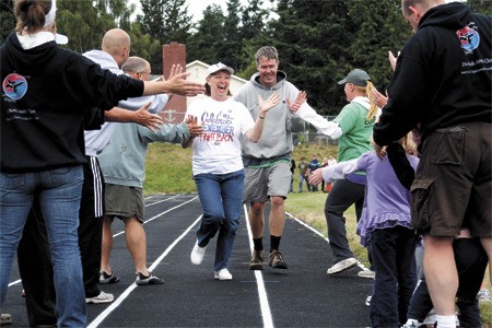 Judy Cornell receives high-fives as she finishes a final lap at a previous Relay for Life event.