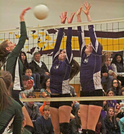 Right; Kendra Meeker and Maddie Williamson stretch high to block a potential winner in the Wolverines win at home Sept. 27 over Evergreen Lutheran.