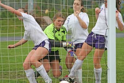 The Wolverines converge at the net for a goal in a mid-season victory at home over Evergreen Lutheran.