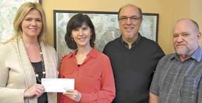 Left; Amy Saxe of OPALCO Energy Services program presents a check to San Juan Isladns Conservation District's Linda Lyshall. Also pictured