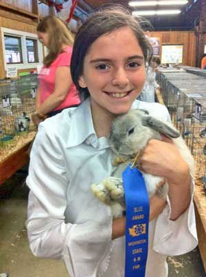 Friday Harbor's Jersie Angel poses for a photo with her state fair blue-ribbon winning bunny.