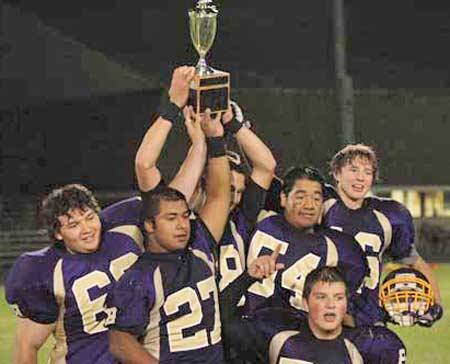 The Wolverines hoist the Island Cup trophy high in celebration of their 41-0 victory over Orcas