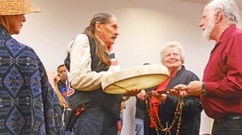 Samish Nation Councilman Dave Blackton presents a custom-made hand drum to San Juan Historical Society board member Don Nixon and Society President Mary Jean Cahail