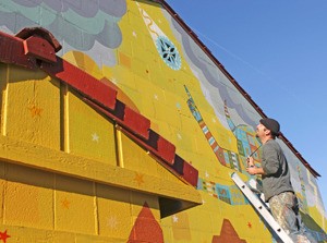 Thomas Christopher Haag at work on a mural next to his gallery at Surina Business and Retail Park