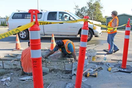 Town workers install a new curb and walkway on Spring Street