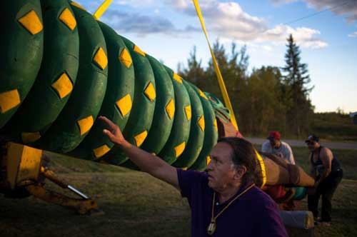 Master carver James Jewell guides the totem pole at the raising ceremony. The totem was carried across state lines to unite communities in protest of the Cherry Point coal terminal.