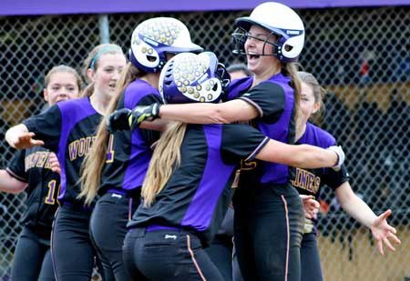 The Wolverines celebrate a home run by Lauren Ayers (far left) in their league title-clinching May 12 win at home over Darrington