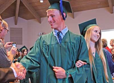 Spring Street International School’s Jed Lewis and Gita Roloff are greeted with applause and handshakes at the Class of 2014 commencement ceremony Saturday