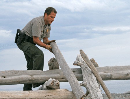 Chief Ranger Barry Lewis dismantles a driftwood fort at South Beach