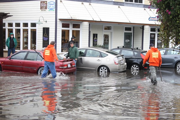 City workers unplug drains on Front Street.