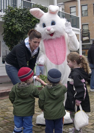 Natalie Chevalier helps the Easter bunny hand out candy in front of the Hotel de Haro during Roche Harbor’s Easter  celebration in 2008. The bunny and his (or her?) pals will be back on the island dispensing holiday fun.