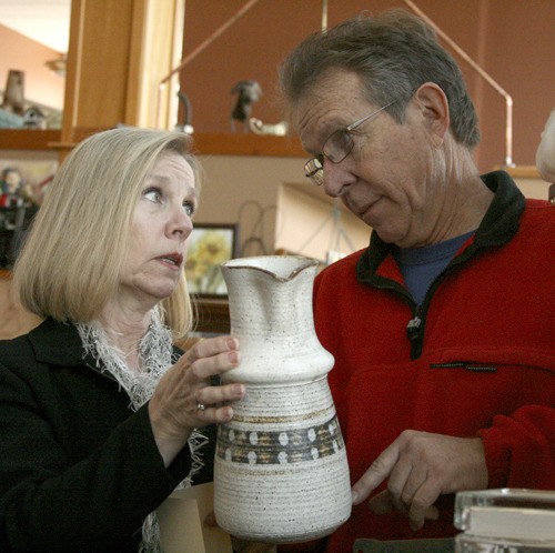 Rebecca Hughes and Howard Cowell of “Howard’s Sell It Again” consignment store deliberate over the value and marketing of a vase.