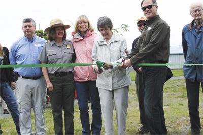 ACT benefactor Laura Nishitani cuts the ribbon at the grand opening of the American Camp Trail in Friday Harbor.