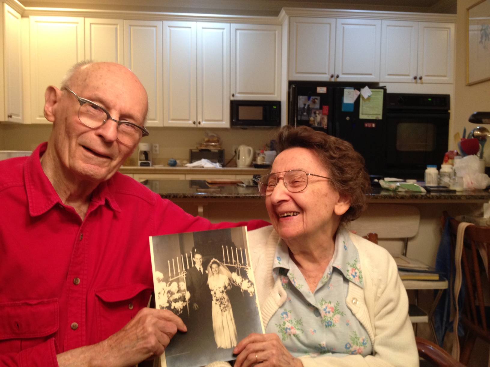 Contributed by Rae Kozloff. Eugene and Anne Kozloff showing off their wedding photo.