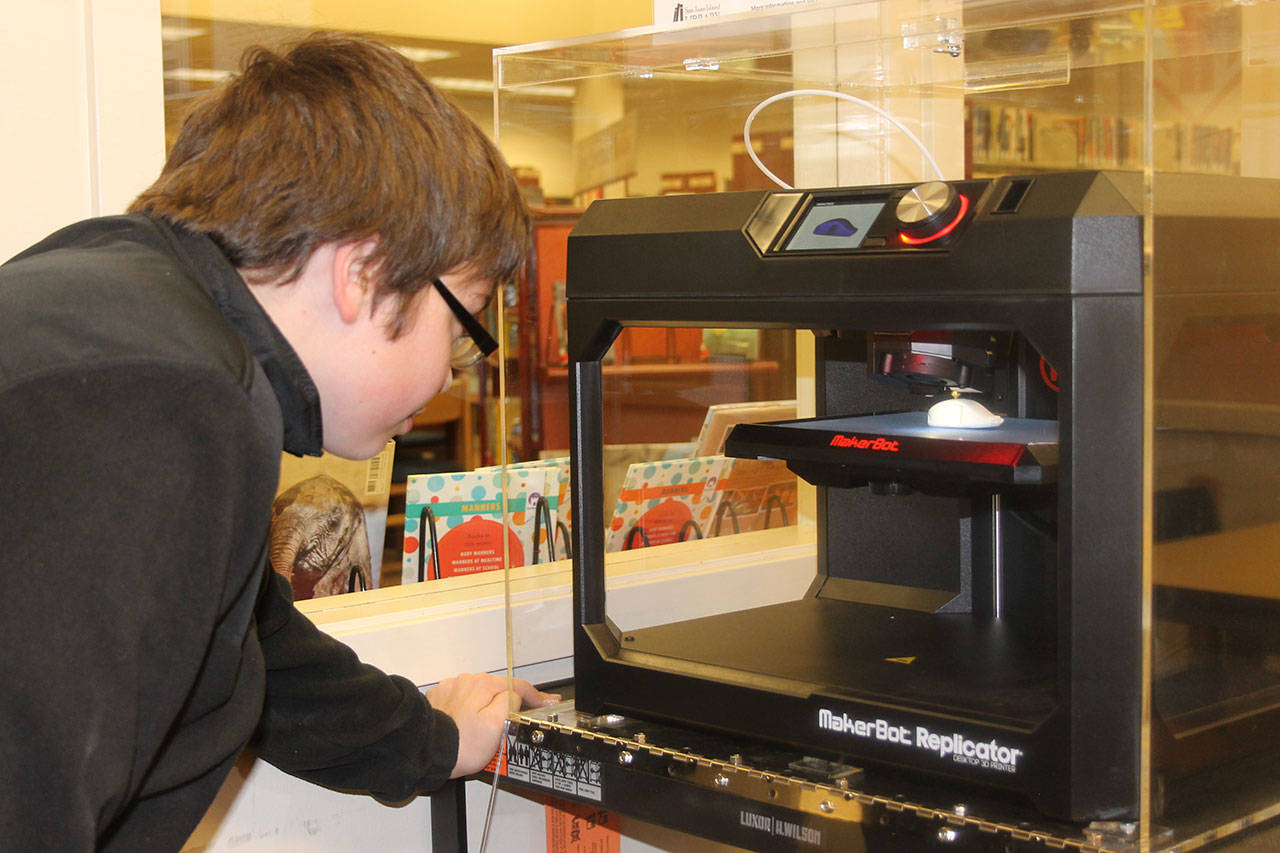 Staff photo/Hayley Day                                Masen Lineback, a freshman at Friday Harbor High School, watches the library’s first 3-D printing test, last November.