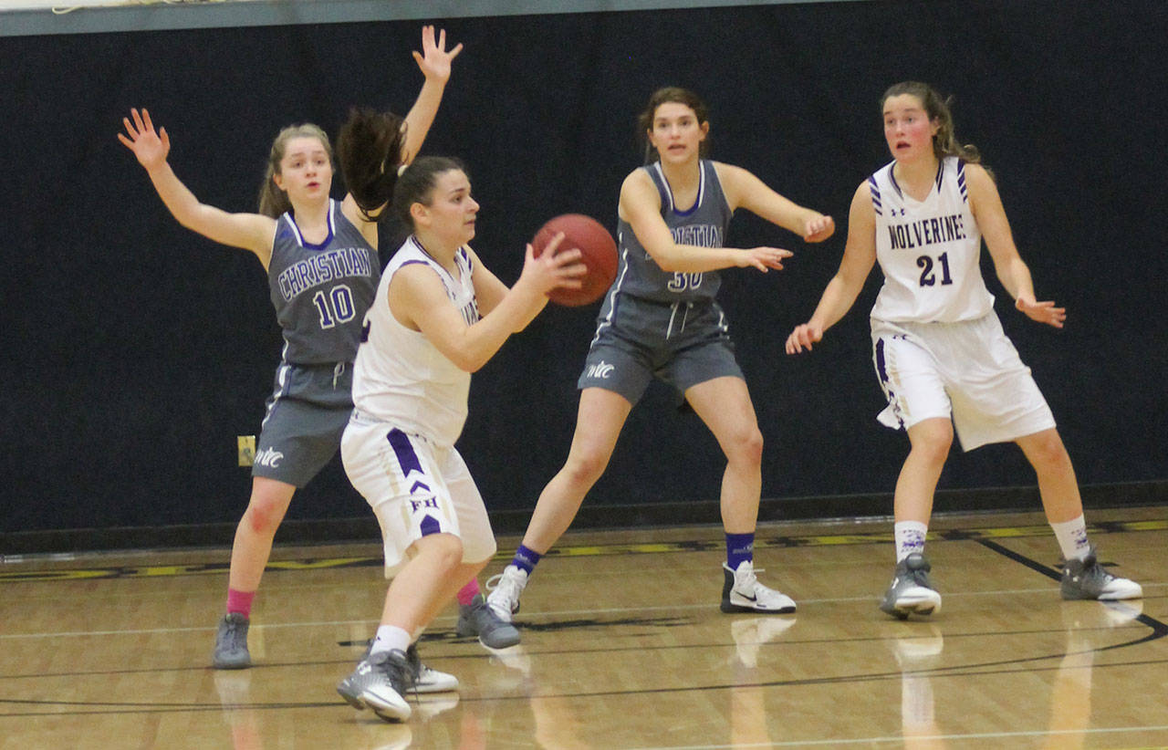 Staff photo/Heather Spaulding                                Sophomore Liz Cruz passes to her teammate while sophomore Bailee Lambright tries to keep herself open and ready.