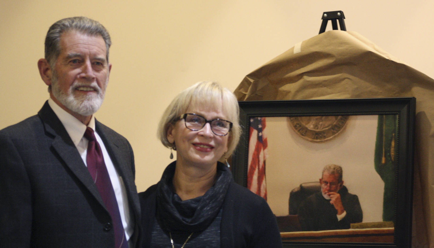 Staff photo/Hayley Day                                San Juan County Superior Court Judge Donald Eaton and his wife Sheryl smile in front of a portrait painted by Barnaby Zall, a local attorney.