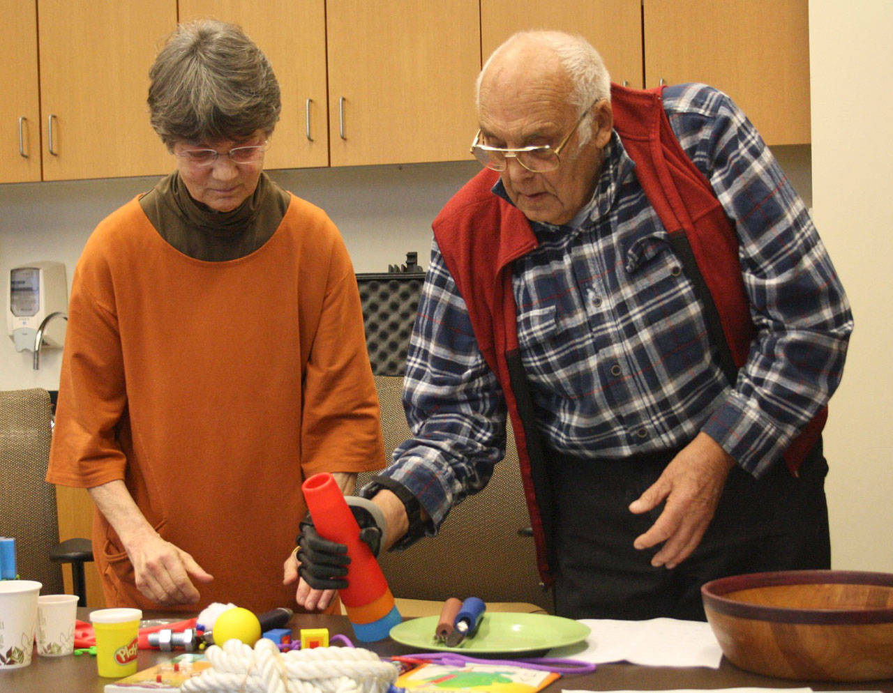 Staff photo/Hayley Day                                Patricia Schnier, a certified hand therapist, watches as Lyle Mann picks up items with his bionic hand.