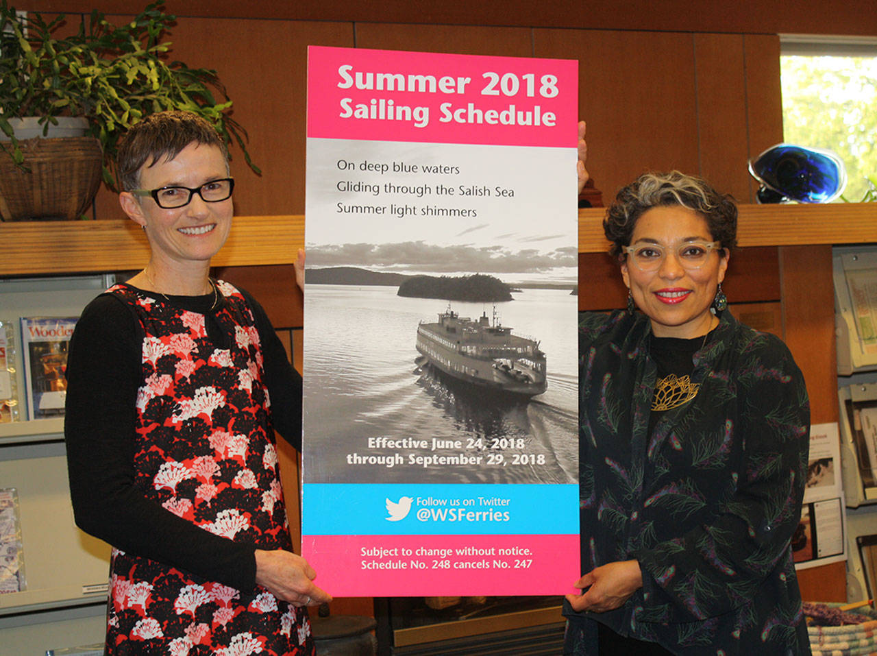 Staff photo/Hayley Day                                Lisa Salisbury, Washington State Ferries online haiku contest, and Washington State Poet Laureate Claudia Castro Luna hold a poster of the summer WSF schedule, where Salisbury’s poem will be showcased.
