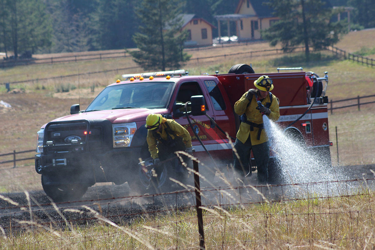 Staff photo/Hayley Day                                Firefighters put out a wildfire on Beaverton Valley Road.
