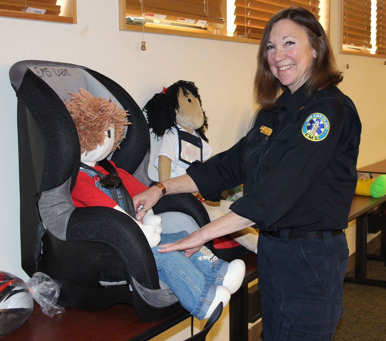 Staff photo/Hayley Day                                Lainey Volk, a director at San Juan Island EMS, demonstrates how to secure a child into a car seat.