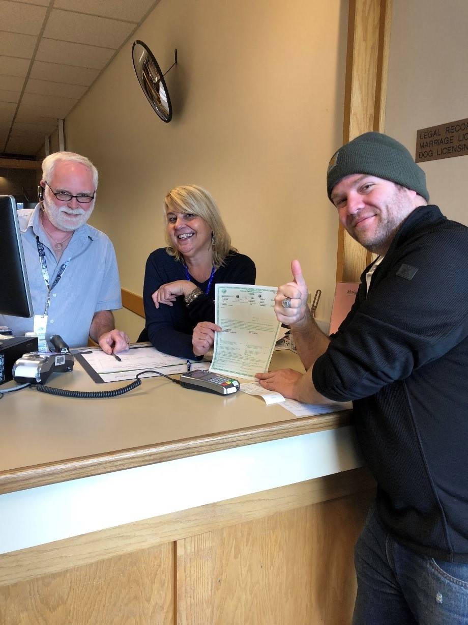 Contributed photo/San Juan County                                Ryan Palmateer receives his quick title from San Juan County Auditor employees Oren Combs and Kira Sable.