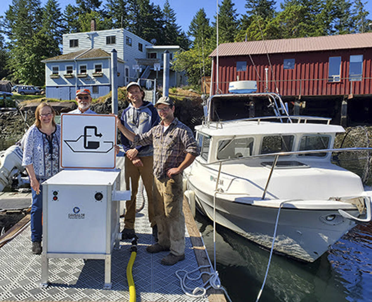 Washington State Parks/Contributed photo                                (From left to right): Owners Terri and Steve Mason and employees Nick Burne and Jonathan Hogue stand by the new pumpout facility located at the Shaw Island General Store.