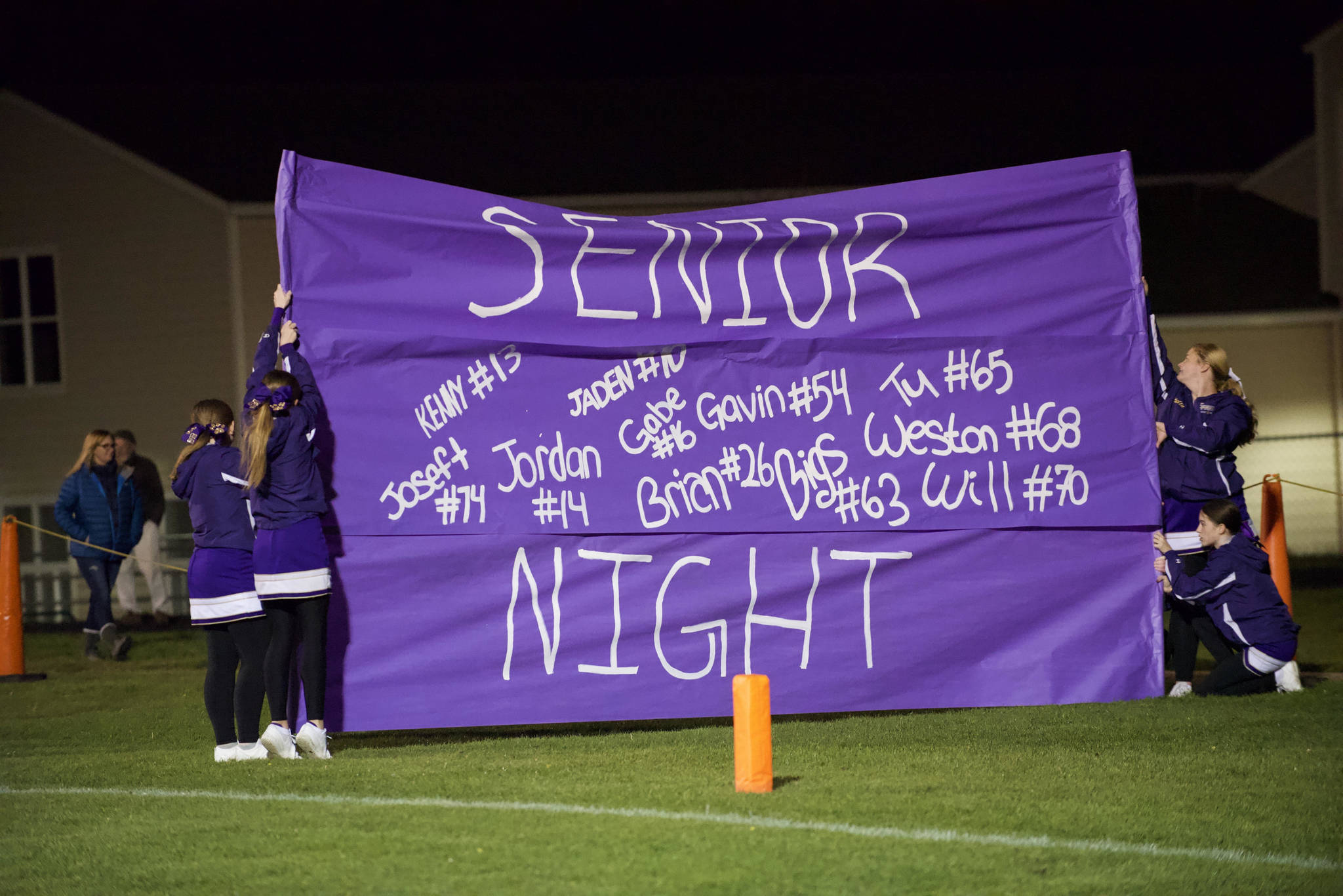 The Cheer Squad waits for the Wolverine Team to run through their banner celebrating Senior Night. (John Stimpson/Contributed photo.)