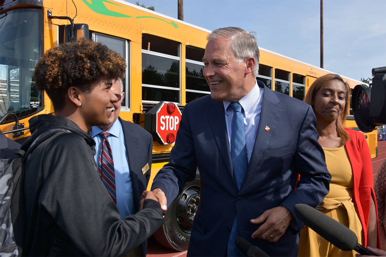 Contributed photo                                At left: Gov. Jay Inslee speaks to students and education leaders after he rode the electric bus around the stadium track. A full electric charge can power the bus to travel 120 miles.