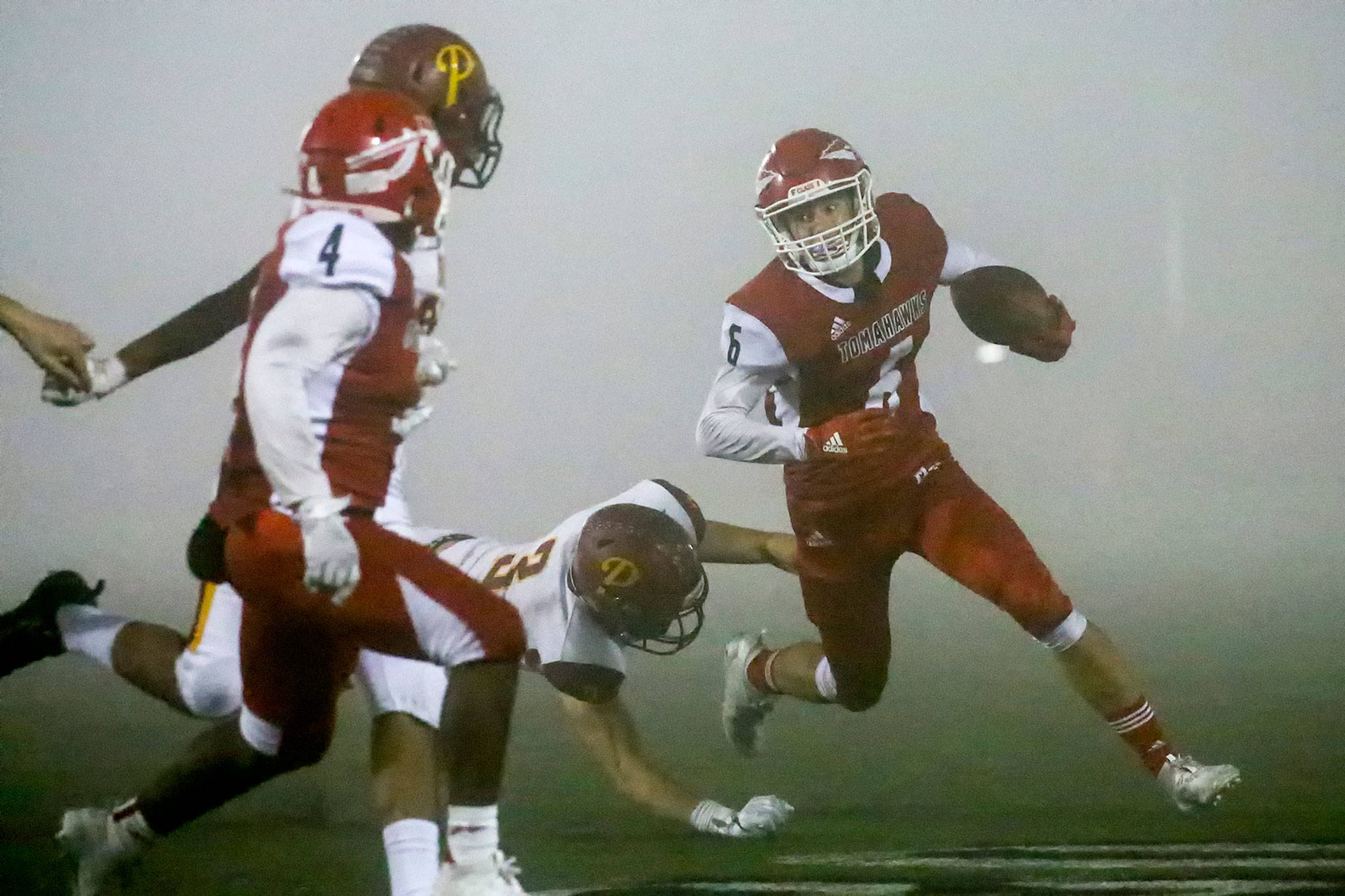 Marysville Pilchuck’s Dillon Kuk carries the ball with Prairie’s Ian Davis trailing during a playoff game on Nov. 15, 2019, at Quil Ceda Stadium in Marysville. (Kevin Clark / The Herald)