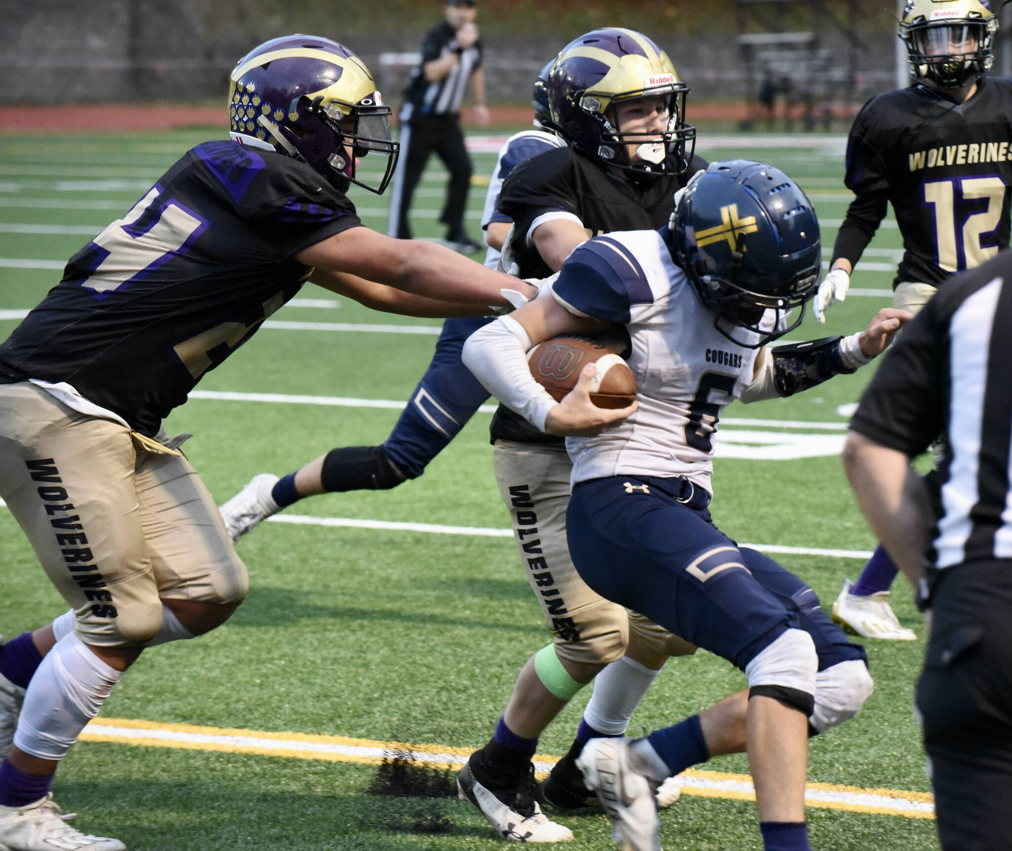 Wolverine’s Chris Gustafson, #24, and Whiley McCutcheon, #34, stop the Cougars’ running back. (John Stimpson photo)