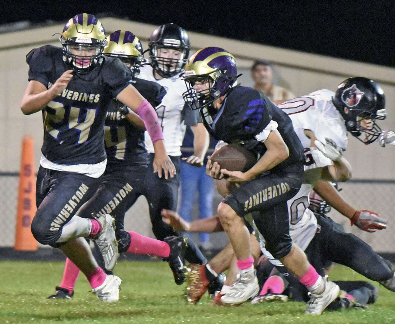 Wolverine Connor Haines, #14, cuts upfield for more yardage, with Chris Gustafson, #24, clearing the way. (John Stimpson)