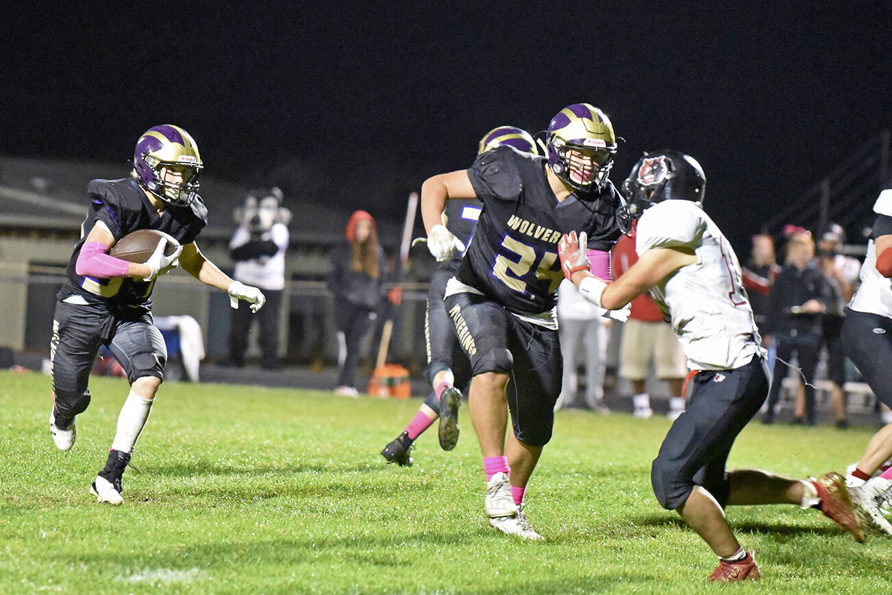Wolverines Whiley McCutcheon, #34, runs for yardage with Chris Gustafson, #24, clearing the way. (John Stimpson)