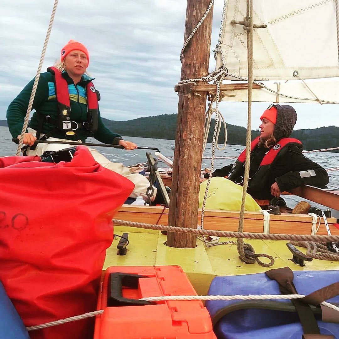 Team Sockeye Voyages crew members Tara Watkins at the helm with Olivia Lord on watch during the 2022 R2AK Race To Alaska.