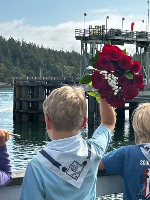Heather Spaulding \ Staff photo
A Cub Scout tossing flowers into the harbor.
