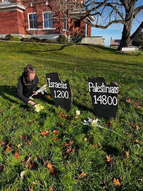 Contributed photo
Daisy Roth sets flowers by the signs at the courthouse.
