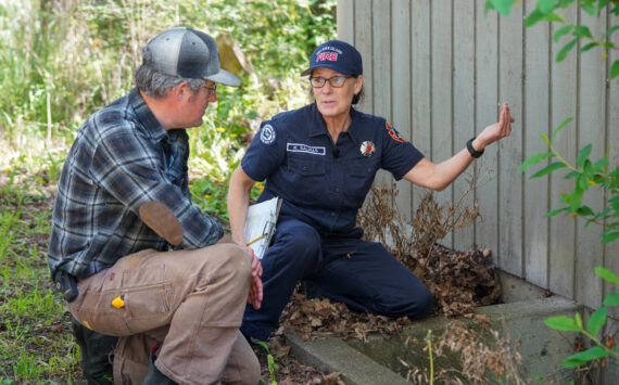Photo credit: Washington Department of Natural Resources
San Juan Island EMS and Fire and Rescue volunteer Kathleen Salinas conducting an at-home fire risk assessment with Adam Green as part of the launch of Wildfire Ready Neighbors, an initiative to help prepare communities to protect their homes from wildfires.