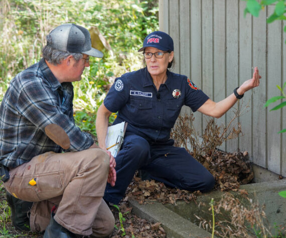<p>Photo credit: Washington Department of Natural Resources</p>
                                <p>San Juan Island EMS and Fire and Rescue volunteer Kathleen Salinas conducting an at-home fire risk assessment with Adam Green as part of the launch of Wildfire Ready Neighbors, an initiative to help prepare communities to protect their homes from wildfires.</p>