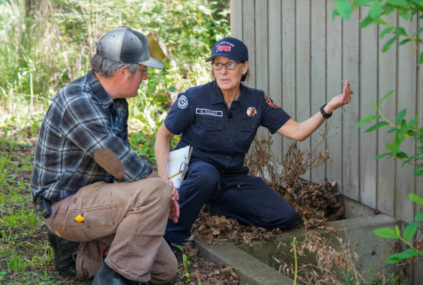 <p>Photo credit: Washington Department of Natural Resources</p>
                                <p>San Juan Island EMS and Fire and Rescue volunteer Kathleen Salinas conducting an at-home fire risk assessment with Adam Green as part of the launch of Wildfire Ready Neighbors, an initiative to help prepare communities to protect their homes from wildfires.</p>