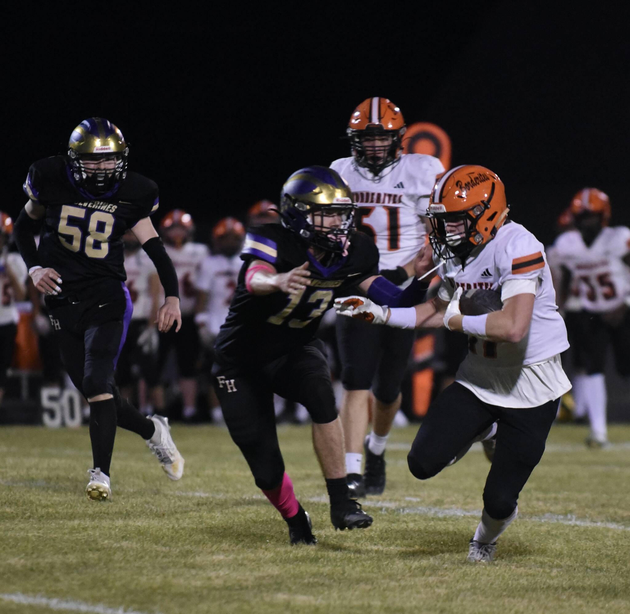 John Stimpson photo.
Wolverine #13 Duncan Bogart closes in to stop the running back.