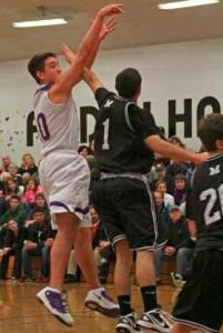 Friday Harbor sophomore C.J. Woods buries a jumper over the outstretched arm of Meridian's Alijah Garcia. Woods tossed in nine points in the Wolverines 45-36 victory at home Friday over the Trojans.